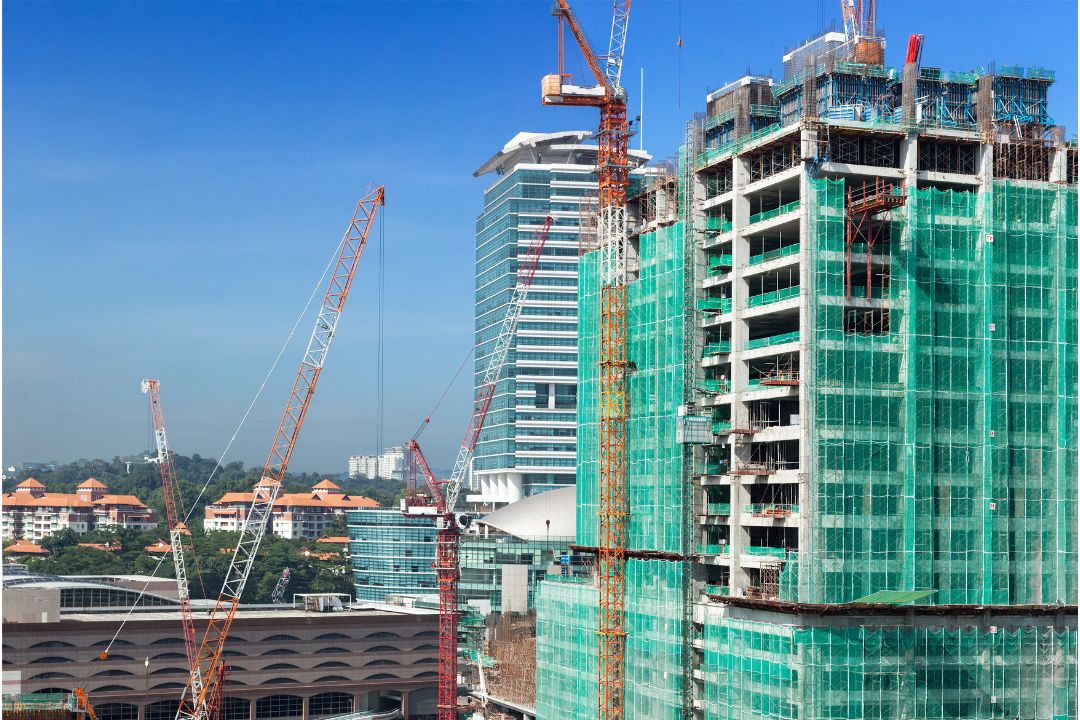 Construction building site with architectural, cost estimating and takeoff tools and estimating software, representing the importance of accurate building estimating services for wise construction decisions and avoiding shortfalls and over runs